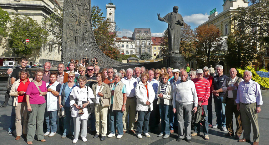 Reisegruppe vor dem Freiheitsdenkmal in Lemberg, dem heutigen Lviv